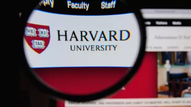 Photo of Harvard University homepage on a monitor screen through a magnifying glass 